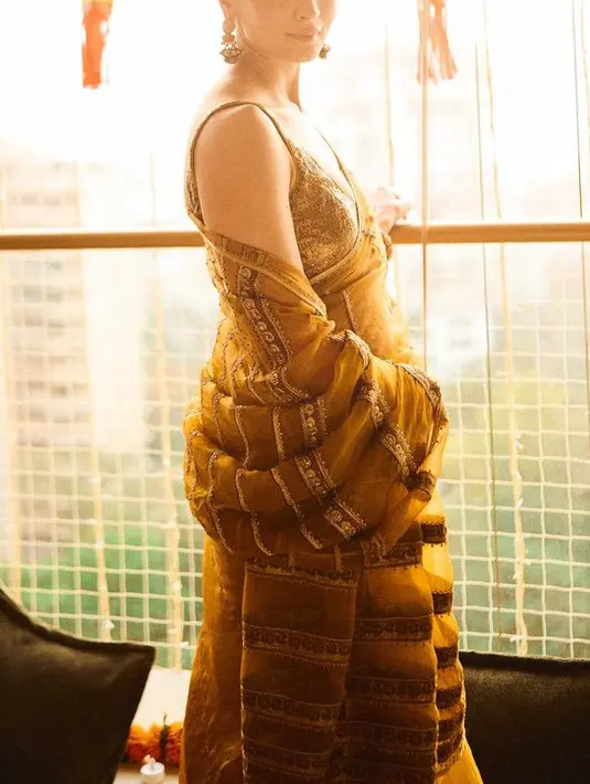 Alia Bhatt tampil dengan saree warna kuning dengan inner spaghetti strap dipadukan selendang yang dihiasi payet. Senada dengan warna roknya. [@aliaabhatt]