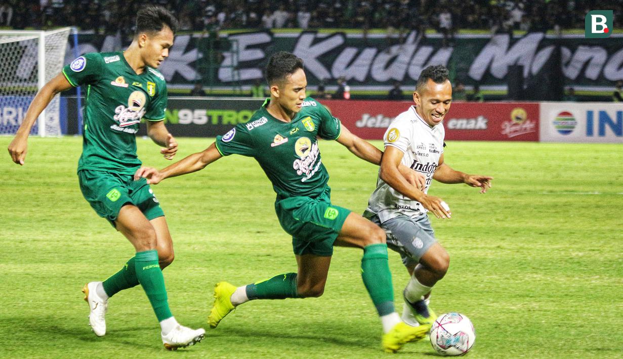 Irfan Jaya (kanan) sejatinya hanya sebentar menyapa mantan timnya. Ia masuk di menit keempat injury time babak kedua. Walau sebentar, ia langsung mendapatkan 'kado' selamat datang dari bek Persebaya, Rizky Ridho (tengah). (Bola.com/Wahyu Pratama)