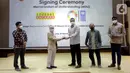 Resident Representative UNDP Indonesia, Norimasa Shimomura (kedua kiri) dan Presdir & CEO Indosat Ooredoo, Ahmad Al-Neama (tengah) bertukar cindermata usai menandatangani MoU penanggulangan pandemi COVID-19 dan percepatan pencapaian SDGs, di Jakarta, Rabu (31/3/2021). (Liputan6.com/Pool/Indosat)