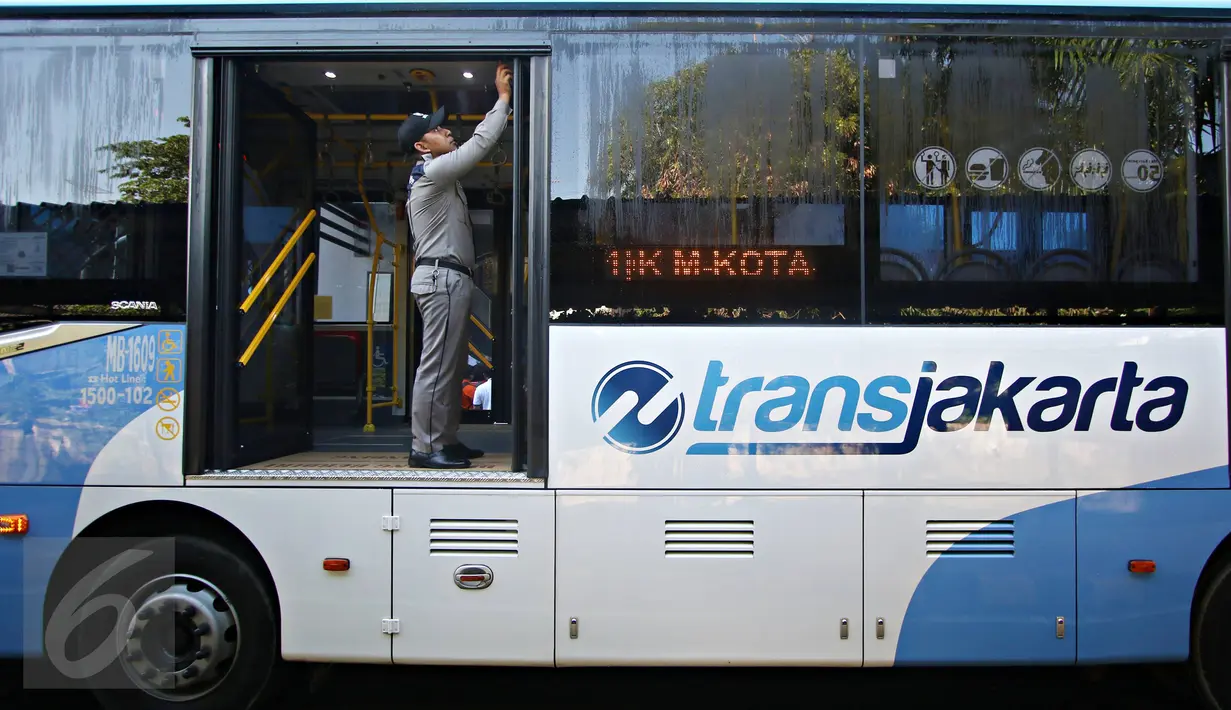 Seorang petugas memeriksa pintu bus Transjakarta baru saat peluncuran di Jakarta, Senin (18/4). Transjakarta resmi meluncurkan 600 unit bus single dan 51 bus gandeng baru yang akan menyebar di 17 rute. (Liputan6.com/Immanuel Antonius)
