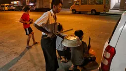 Warga memukul panci, wajan, dan berbagai benda untuk membuat keributan memprotes kudeta militer di Yangon, Myanmar, 2 Februari 202. Warga membunyikan klakson mobil dan panci serta wajan yang berdenting sebagai protes atas kudeta militer Myanmar. (STR/AFP)