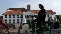 Warga menggunakan sepeda wisata di kawasan Kota Tua Jakarta, Kamis (29/10/2020). Libur panjang di masa pemberlakuan PSBB transisi Jakarta dimanfaatkan warga untuk mengunjungi lokasi-lokasi wiisata. (Liputan6.com/Helmi Fithriansyah)