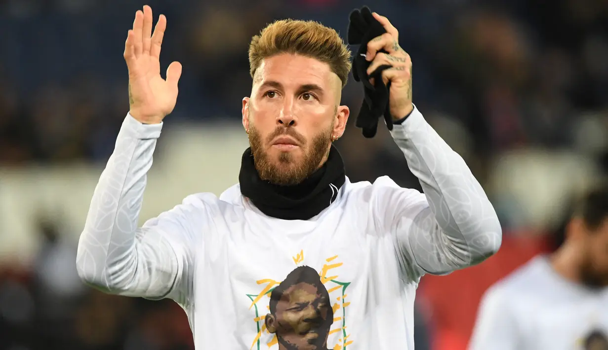 Bek Paris Saint-Germain (PSG) Sergio Ramos, memberi isyarat saat mengenakan kaos dengan potret mendiang legenda sepak bola Brasil Pele sebelum lanjutan Liga Prancis 2022/2023 melawan Angers di Parc des Princes, Kamis (12/1/2023) dini hari WIB. Sebagaimana diketahui, Pele meninggal dunia pada akhir Desember 2022 lalu di usianya yang ke-82 tahun. (Bertrand GUAY / AFP)