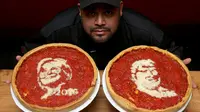 Chief Cook, Fabian Martinez berpose dengan pizza bergambar wajah calon presiden AS dari Partai Republik, Donald Trump dan rivalnya dari Partai Demokrat, Hillary Clinton di Giordano Pizzeria, Chicago, Selasa (27/9). (REUTERS / Jim Young)