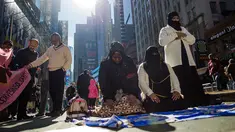 Sejumlah perempuan Muslim menunaikan salat dalam unjuk rasa mendukung Muslim Amerika dan aksi protes kebijakan imigrasi Presiden Donald Trump di Times Square, New York, Minggu (19/2). (AP/Andres Kudacki)