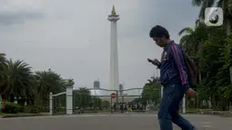 Pejalan kaki berjalan di kawasan Monumen Nasional (Monas) yang akan dijadikan arena lintasan balapan Formula E 2020, Jakarta, Selasa (11/2/2020). Ajang ini dilakukan di kawasan Monas setelah mendapatkan persetujuan dari Komisi Pengarah Kawasan Medan Merdeka. (merdeka.com/Imam Buhori)