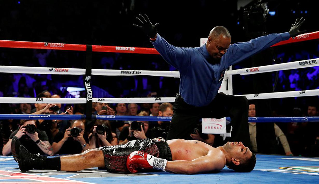 Wasit menghentikan pertandingan setelah Amir Khan dipukul jatuh oleh Saul Alvarez dalam laga kelas menengah WBC di T-Mobile Arena, Las Vegas, AS, (7/5/2016). Amir Khan sempat pingsan setelah jatuh ke kanvas. (Action Images via Reuters/Andrew Couldridge)