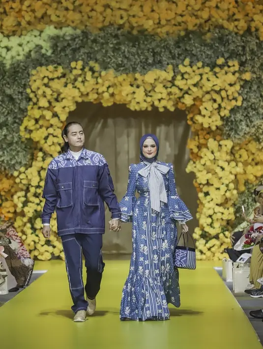 Pasutri Roger-Cut Meyriska tampil kompak pakai busana nuansa biru yang mencolok. (Credits/Tim Muara Bagdja).