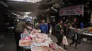Aktivitas pasar di Kota Gaza menunjukkan tanda-tanda pemulihan secara bertahap menyusul perjanjian gencatan senjata antara Hamas-Israel di Gaza di bawah pengawasan Amerika Serikat, Mesir, Turki, dan Qatar berlaku sejak 10 Oktober 2025. Tampak dalam foto, seorang warga Palestina melihat potongan ayam yang dipajang untuk dijual di pasar jalanan setempat di Kota Gaza, Jumat, 19 Desember 2025. (AP Photo/Abdel Kareem Hana)