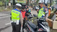 Petugas lantas Polres Garut, tengah melakukan pemeriksaan surat kendaraan saat penerapan sistem tilang manual. (Liputan6.com/Jayadi Supriadin)