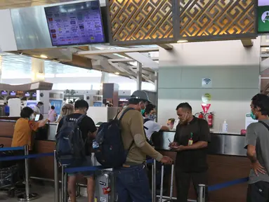 Calon penumpang mengantre di pelayanan tiket di Terminal 3 Bandara Soekarno Hatta, Tangerang, Banten, Selasa (10/11/2020). Maskapai penerbangan Garuda Indonesia dan Citylink melakukan penyesuaian beberapa jadwal penerbangan. (Liputan6.com/Herman Zakharia)