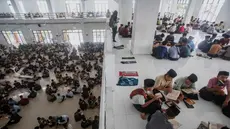 Para siswa duduk melingkar sambil membaca Al-Quran selama bulan suci Ramadan 1447 Hijriah di Pondok Pesantren Ar-Raudlatul Hasanah di Medan, Sumatera Utara, Sabtu 21 Februari 2026. Pelajar atau santri di Pesantren Tarbiyah Islamiyah Ar-Raudlatul Hasanah di Medan, Sumatera Utara, kembali melaksanakan tradisi unik tadarus Al-Quran. (AP Photo/Binsar Bakkara)