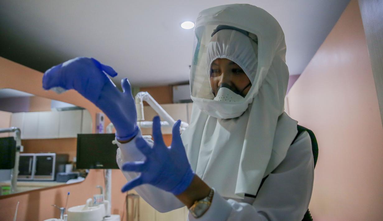 Dr. Maureen P. Ines-Manzano, seorang dokter gigi, mengenakan setelan respirator dengan pemurni udara di dalam kliniknya di Manila, Filipina, pada 19 Oktober 2020. Pasien Dr. Manzano menjulukinya "dokter gigi astronaut" karena mengenakan setelan PAPR utuk menghindari COVID-19. (Xinhua/Rouelle Umali)