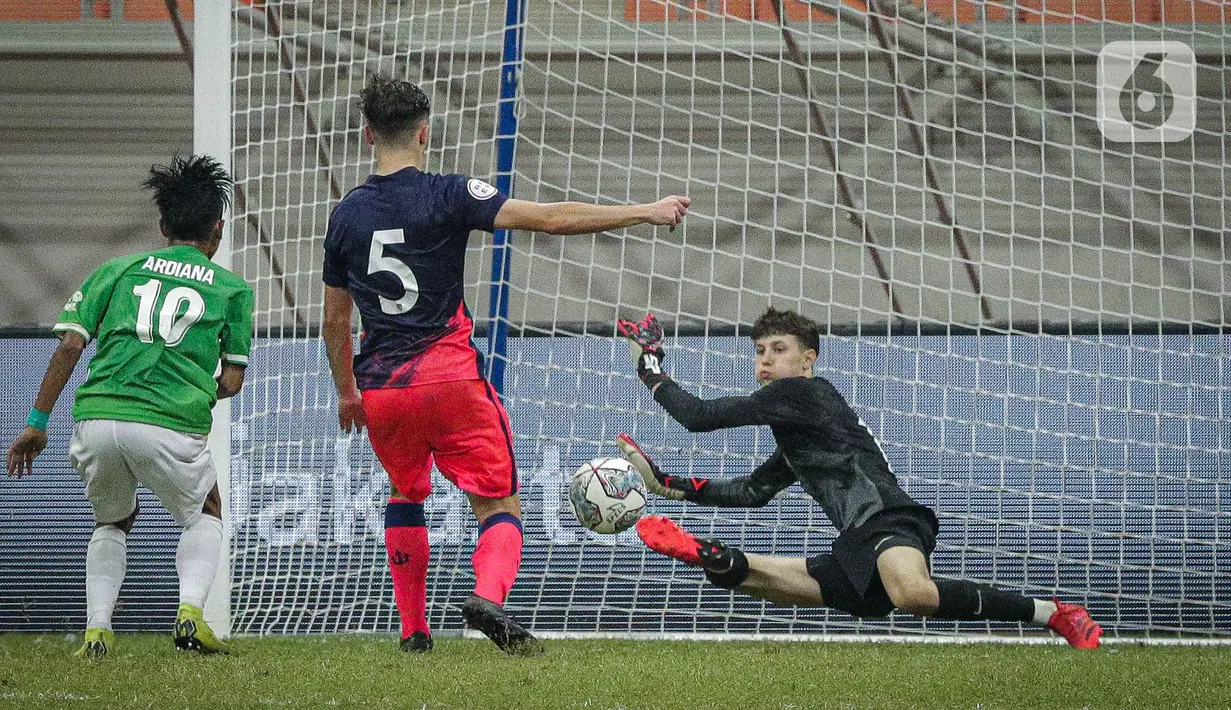 Kiper Atletico Madrid U-18 menyelamatkan gawangnya dari serangan pemain Indonesia All Stars U-20 Ardi Ardiana pada laga ketiga International Youth Championship (IYC) 2021  di Jakarta International Stadium (JIS), Minggu (17/4/2022). Atletico Madrid U-18 menang tipis 2-1. (Liputan6.com/Faizal Fanani)