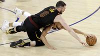 Pemain Warriors, Stephen Curry (bawah) berebut bola dengan pemain Cavaliers, Kevin Love pada gim pertama final NBA basketball di Oakland, California, (31/5/2018). Warriors menang 124-114. (AP/Marcio Jose Sanchez)