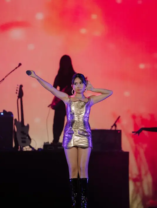 Di sini, Niki mengenakan mini dress bernuansa emas, yang kembali dipadunyadengan sepatu boots hitam berbahan kulit. Foto: Instagram.