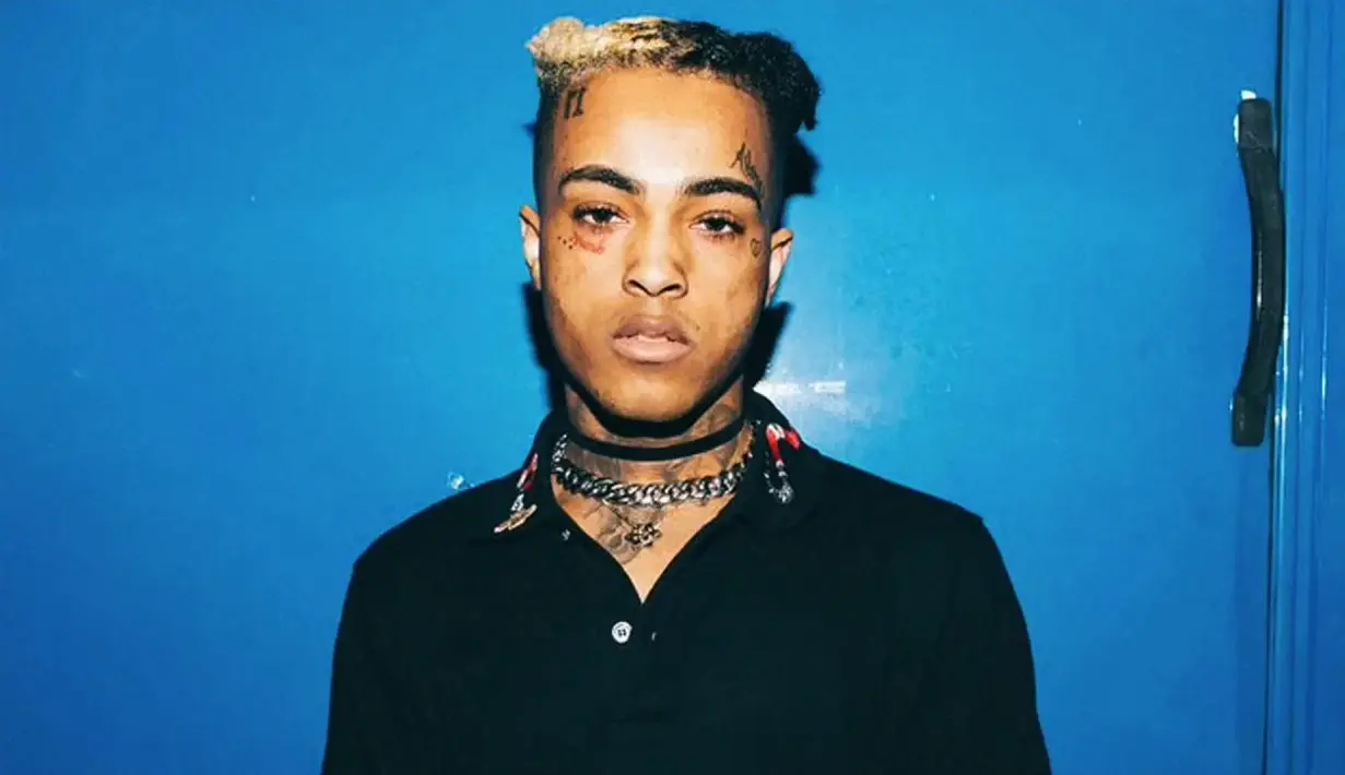 Geneva sendiri membawakan bunga mawar, globe, dan sebuah tanda R.I.P Jahseh yang merupakan nama asli XXXTentacion. (Know Your Meme)
