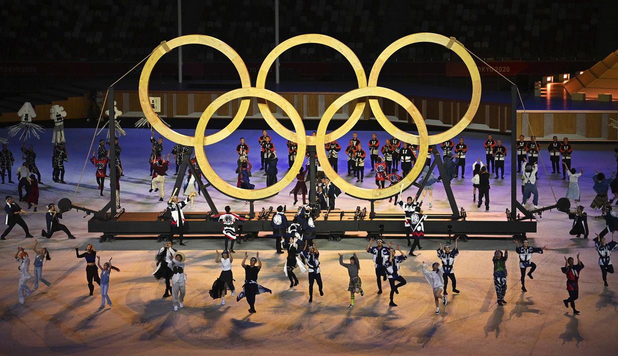 Para penari tampil di depan logo Olimpiade saat upacara pembukaan Olimpiade Tokyo 2020 di Olympic Stadium, Tokyo, Jepang, Jumat (23/7/2021). (Foto: AP/Pool/Dylan Martinez)