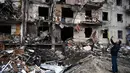 Seorang pria mengambil gambar sebuah bangunan tempat tinggal yang rusak setelah peluru militer Rusia menghantam di Koshytsa Street, Kiev, Ukraina (25/2/2022). Pasukan Rusia mencapai pinggiran Keiv pada hari Jumat (24/2). (AFP/Daniel Leal)