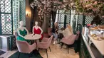 Para pelanggan menyantap makanan di samping maneken yang mengenakan busana kreasi desainer lokal di sebuah kafe di Kota Tua Vilnius, Lithuania, Kamis (21/5/2020). Sejumlah restoran dan kafe di Lithuania memamerkan koleksi busana karya desainer lokal yang terdampak COVID-19. (Xinhua/Alfredas Pliadis)