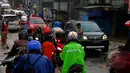 Sejumlah kendaraan mengantri untuk melintasi genangan air setinggi 20cm, di Jalan Joglo Raya, Kampung Gebyuran, Ciledug, Tangerang, Jum'at (23/01/2015). (Liputan6.com/Andrian M Tunay)