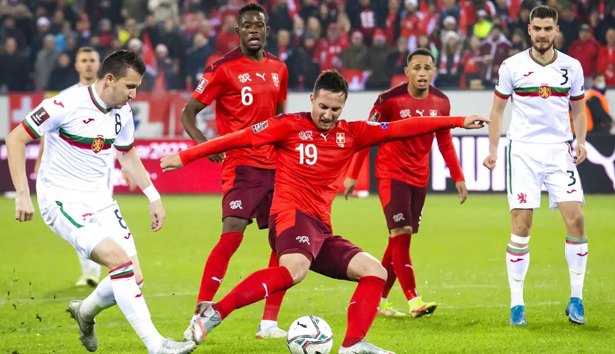 Pemain Swiss Mario Gavranovic (tengah) dan pemain Bulgaria Todor Nedelev memperebutkan bola pada pertandingan sepak bola kualifikasi Piala Dunia 2022 di Stadion Swissporarena, Lucerne, Swiss, 15 November 2021. Swiss menang 4-0. (Urs Flueeler/Keystone via AP)