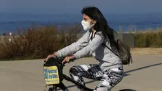 Seorang anak perempuan yang memakai masker menaiki sepeda di Beirut, ibu kota Lebanon (26/12/2020). Menteri Kesehatan Lebanon Hamad Hassan pada Jumat (25/12) mengumumkan bahwa seorang penumpang yang tiba di Beirut dari Inggris membawa varian baru COVID-19. (Xinhua/Bilal Jawich)