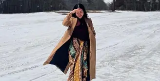 Tampil berkain tetap modis, pelantun lagu ‘Dunia Tipu-tipu’ ini menambahkan coat dan turtleneck top. [Foto: IG/yurayunita].
