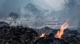 Bara api masih terlihat di antara puing-puing setelah sebagian besar bangunan hangus terbakar dalam kebakaran hutan di Kuil Gounsa, Uiseong, Korea Selatan pada 26 Maret 2025. (YASUYOSHI CHIBA/AFP)