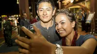 Pebalap Formula 1 asal Indonesia, Rio Haryanto, selfie bersama fans yang menyambutnya di Bandara Soekarno-Hatta, Tanggerang. (Bola.com/Vitalis Yogi Trisna)