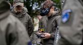 Seorang mahasiswa bernama Bartosz Ladocha mengenakan kacamata khusus untuk mengendalikan drone FPV (first-person-view) saat mengikuti kursus drone di Sekolah Militer, Legnica, Polandia Barat, pada 8 Oktober 2025. (Wojtek RADWANSKI/AFP)