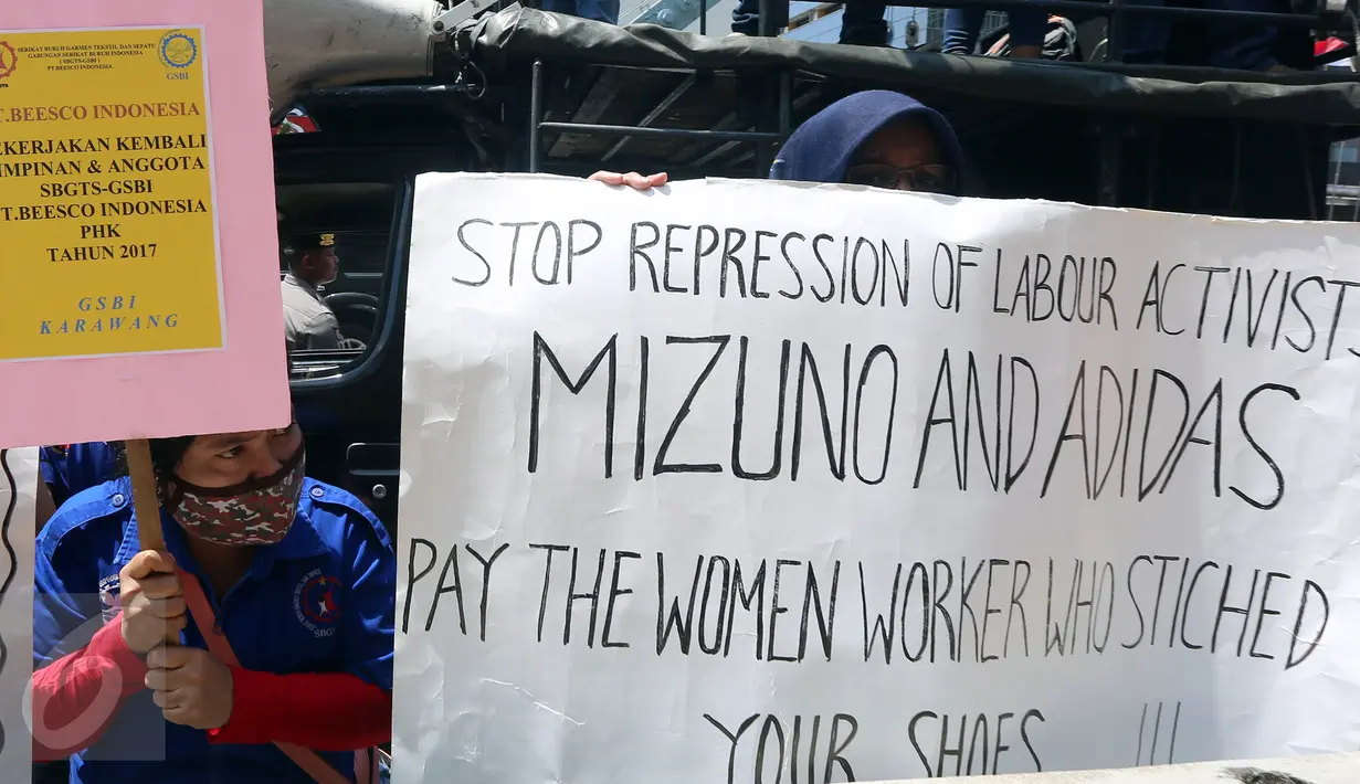 Massa membentangkan poster berisi tuntutan di depan Kedubes Jepang, Jakarta, Kamis (20/4). Para buruh itu menuntut upah pemutusan hubungan kerja atas perusahaan brand asal Jepang yang belum dibayar selama 3 tahun. (Liputan6.com/Johan Tallo)
