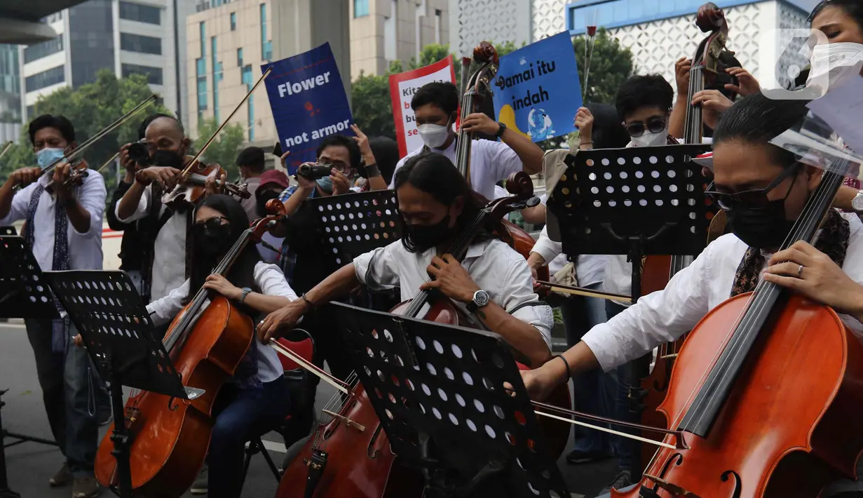 Penampilan orkestra saat aksi seruan damai di depan Kedutaan Besar Federasi Rusia, Jakarta, Rabu (30/3/2022). Aksi tersebut mengangkat tema "Setangkai Kembang dan Satu Nyanyian" dengan membawakan lagu Rayuan Pulau Kelapa versi bahasa Rusia. (Liputan6.com/Herman Zakharia)