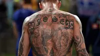 Pemain Yunani, Chose Cholevas memiliki tato unik saat berjalan keluar arena pada partai persahabatan melawan Australia di Sidney. (AFP/Saeed Khan)