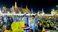 Raja Thailand Maha Vajiralongkorn (tengah kiri) dan Ratu Suthida (tengah kanan), melambaikan tangan ke arah para demonstran di Bangkok, Thailand, Minggu, 1 November 2020. (AP)
