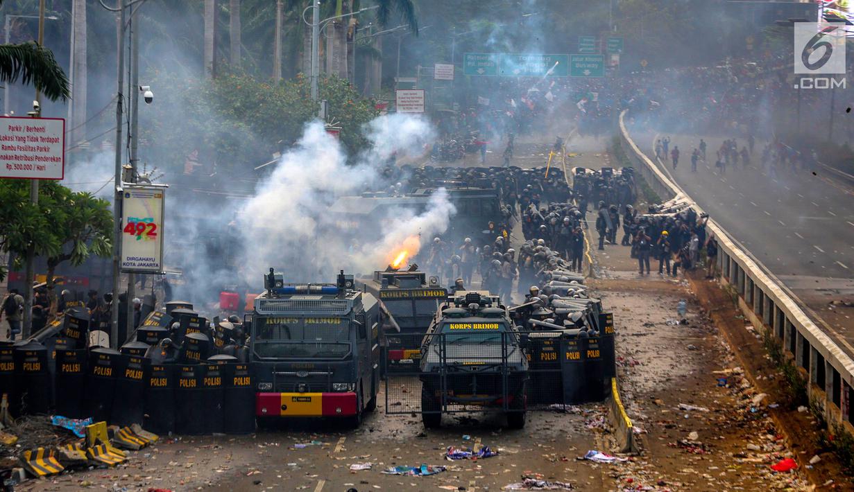 Polisi membuat barikade saat menghalau mahasiswa dalam demonstrasi menolak pengesahan RUU KUHP dan revisi UU KPK di depan Gedung DPR, Jakarta, Selasa (24/9/2019). Semprotan water cannon dan tembakan gas air mata memaksa mahasiswa mundur. (Liputan6.com/Faizal Fanani)