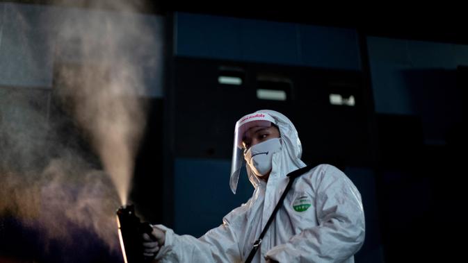 Karyawan menyemprotkan disinfektan sebagai tindakan pencegahan terhadap Covid-19 di bioskop Paragon Cineplex di Bangkok, Thailand, Senin (1/6/2020). (AP Photo/Sakchai Lalit)