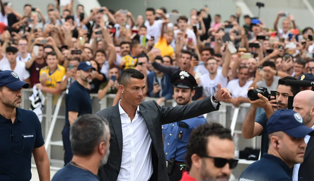 Para suporter menyambut kedatangan bintang baru Juventus, Cristiano Ronaldo, saat tiba untuk menjalani tes kesehatan di area Stadion Allianz, Turin, Senin (17/7/2018). CR 7 hijrah dari Real Madrid ke Juventus. (AFP/Miguel Medina)