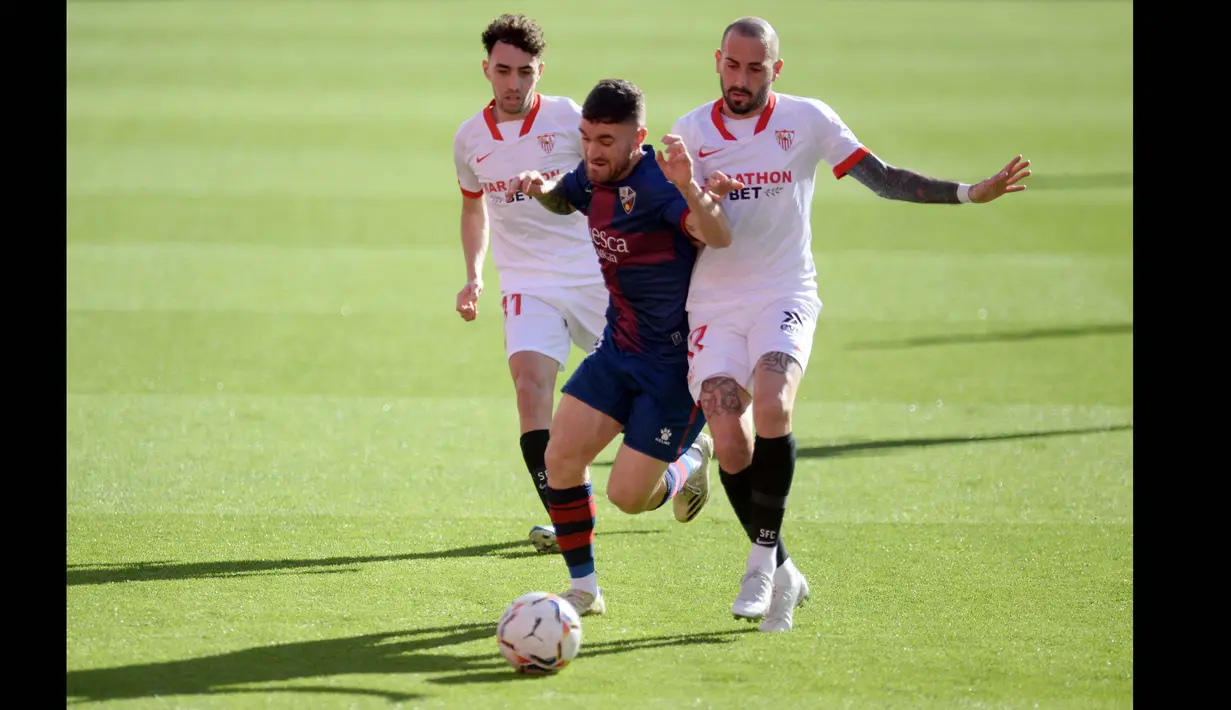 Pada urutan ketiga raja dribel Eropa, ada nama Javi Galan (tengah). Dia memang bermain di klub medioker, Huesca, namun punya catatan dribel sukses mencapai 80.2 persen. Sejauh ini, Javi Galan telah melakukan 93 kali dribel sukses bersama Huesca. (Foto: AFP/Cristina Quicler)