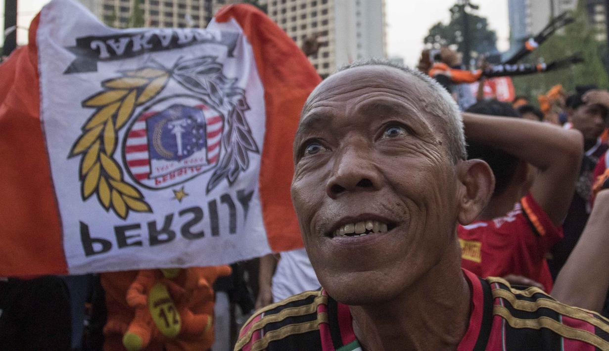 Suporter Persija Jakarta, The Jakmania, merayakan gelar juara Liga 1 saat nonton bareng di Plaza Timur Senayan, Jakarta, Minggu (9/12). Persija juara Liga 1 setelah menang 2-1 atas Mitra Kukar. (Bola.com/Peksi Cahyo)