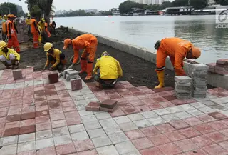Petugas memasang konblok di pinggir Danau Sunter, Jakarta Utara, Senin (19/2). Progres penataan Danau Sunter telah mencapai 70 persen dan menargetkan penataan rampung sebelum pelaksanaan Festival Danau Sunter. (Liputan6.com/Arya Manggala)