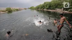 Anak-anak berenang di rawa pesisir Muara Baru, Cilincing, Jakarta, Minggu (15/8/2021). Anak-anak setempat memanfaatkan rawa sebagai wahana berenang akibat keterbatasan lahan bermain di wilayah pesisir tersebut. (merdeka.com/Iqbal S Nugroho)
