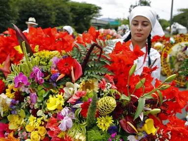 Seorang petani menyiapkan rangkaian bunga yang dikenal sebagai "silleta" sebelum mengikuti parade tradisional Silleteros, yang diadakan sebagai bagian dari Festival Bunga, di Medellin, Kolombia, pada 7 Agustus 2023. (AFP/Fredy Builes)