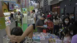 Pengunjung membaca di stan selama pameran buku tahunan di Hong Kong, Rabu (20/7/2022). Pameran Buku Hong Kong akan diadakan pada 20-26 Juli. (AP Photo/Kin Cheung)
