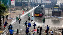 Polisi menyemprotkan air menggunakan water cannon ke arah mahasiswa saat demonstrasi menolak pengesahan RUU KUHP dan revisi UU KPK di depan Gedung DPR, Jakarta, Selasa (24/9/2019). Polisi menyemprotkan air ke arah mahasiswa karena menolak untuk dibubarkan. (Liputan6.com/Faizal Fanani)