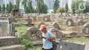 Seorang pria dengan membawa gerobak melintas di sekitar Taman Pemakaman Umum (TPU) Menteng Pulo, Jakarta, Selasa (3/12/2019). Pemprov DKI Jakarta berencana merevitalisasi 17 TPU serta akan melakukan perluasan lahan makam hingga 794,83 hektar. (Liputan6.com/Immanuel Antonius)