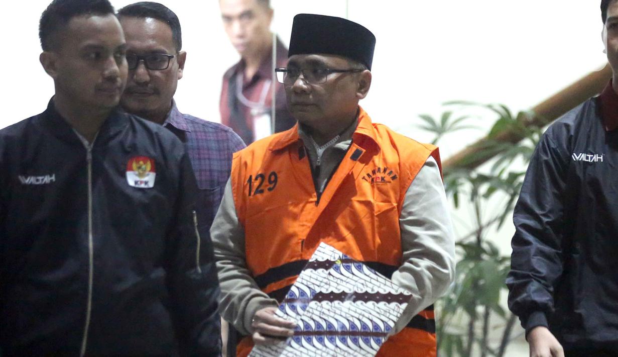 Kedua tangannya terborgol. Dia keluar dan masuk ke dalam mobil tahanan dengan mengenakan rompi oranye serta tangan terborgol yang ditutupi map motif batik. Tampak dalam foto, mantan Menteri Agama, Yaqut Cholil Qoumas, saat dibawa menuju mobil tahanan di Gedung Merah Putih Komisi Pemberantasan Korupsi (KPK), Jakarta, Kamis (12/3/2026). (Liputan6.com/Helmi Fithriansyah)