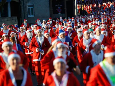 Ribuan peserta mengenakan kostum Santa Claus mengikuti balap lari Santa Dash di Liverpool, Inggris, Minggu (4/12). Lebih dari 8.000 orang diperkirakan mengikuti acara lari 5km Santa Dash yang diselenggarakan tiap tahun tersebut. (Reuters/Phil Noble)