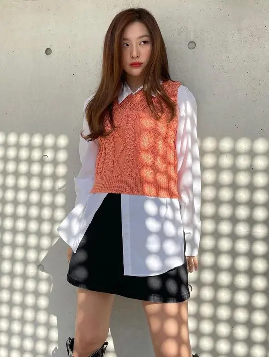 Untuk tampilan smart casual, bisa padukan kemeja dengan vest warna peach. Supaya makin stunning, kombinasikan pula OOTD-mu dengan leather skirt (Instagram/hi_sseulgi).
