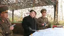 Pemimpin Korea Utara Kim Jong-un dan pasukannya mengecek sebuah peta saat melakukan inspeksi di sebuah detasemen pertahanan di Pulau Mahap, sektor depan Korea Utara. (REUTERS/KCNA)